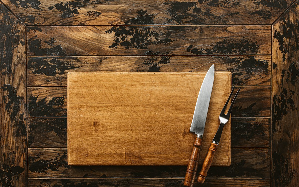 A knife and a board on a wooden surface