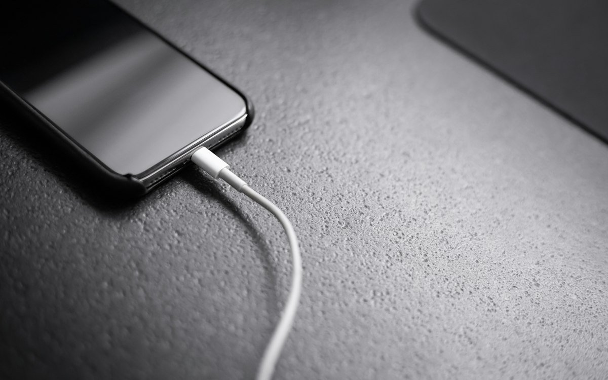 Black smartphone with charger cord connected